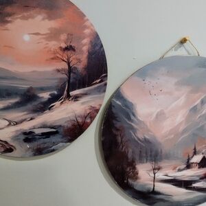 set of two 12" round wooden art prints depicting a snowy landscape.